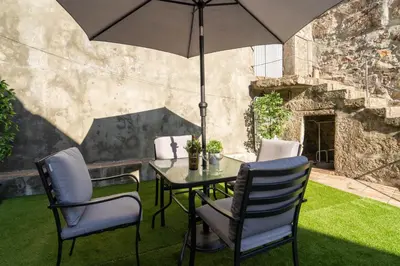 a table and chairs with an umbrella on a lawn at Host Wise - Stylish Adorable Flat in Gaia in Vila Nova de Gaia