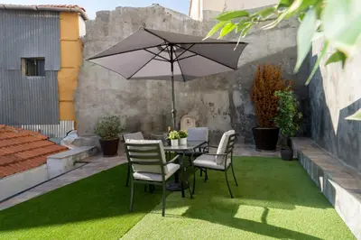 a table and chairs with an umbrella on a lawn at Host Wise - Stylish Adorable Flat in Gaia in Vila Nova de Gaia