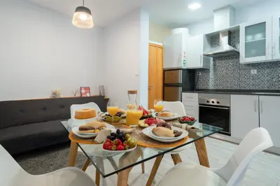 a dining room with a table with food and orange juice at Host Wise - Stylish Adorable Flat in Gaia in Vila Nova de Gaia