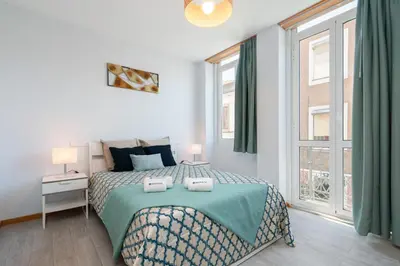 a white bedroom with a bed and a window at Host Wise - Stylish Adorable Flat in Gaia in Vila Nova de Gaia