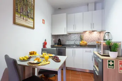 a kitchen with white cabinets and a table with fruit on it at Host Wise - Stylish Adorable Flat in Gaia in Vila Nova de Gaia