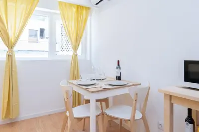 a white dining room with a white table and chairs at Host Wise - Sweet Sunny Flat with Balcony in Vila Nova de Gaia