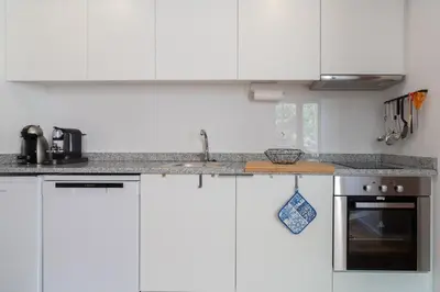 a kitchen with white cabinets and a sink at Host Wise - Sunny Bright Duplexes & Pool in Vila Nova de Gaia