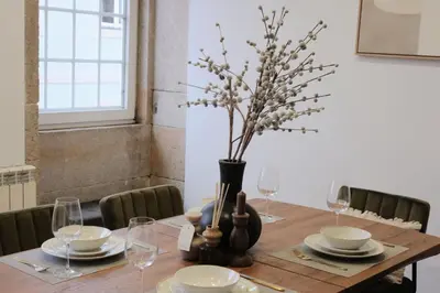 a wooden table with a vase with flowers in it at Downtown Premiu in center of Porto 3BR with AC in Porto