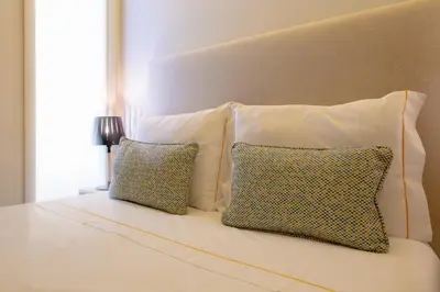 a white bed with two pillows and a headboard at GuestReady - Catorze de Outubro Houses 417 in Vila Nova de Gaia