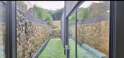 a window view of a yard with a stone wall at Fontainhas Douro Flats in Porto