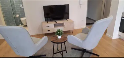 a living room with two chairs and a television at Fontainhas Douro Flats in Porto