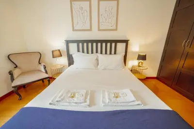 a bedroom with a bed with two towels on it at Downtown Deluxe by Vacationy in Porto