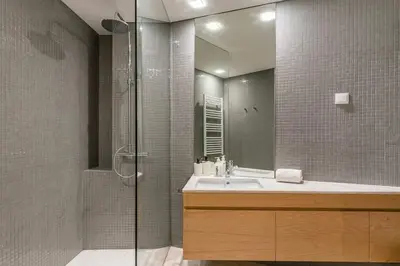a bathroom with a sink and a shower with a mirror at NEW LUX 2BR Flat Free Parking Cedofeita Porto in Porto