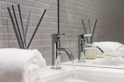 a bathroom sink with two faucets and a mirror at NEW LUX 2BR Flat Free Parking Cedofeita Porto in Porto