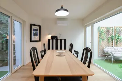 a dining room with a wooden table and chairs at Campanhã Duplex by Porto Stories in Porto