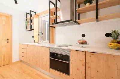 a kitchen with wooden cabinets and a sink at Prime Clerigos by Hosty in Porto