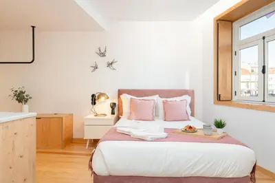 a bedroom with a large bed with pink pillows at Prime Clerigos by Hosty in Porto