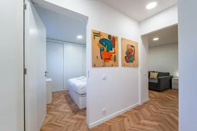 a room with a bed and paintings on the wall at Spritz Hour House in Porto