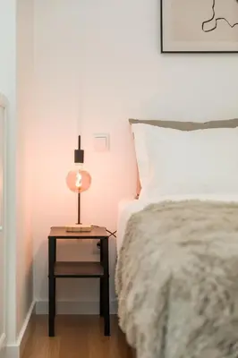a bedroom with a bed and a nightstand with a lamp at Douro's Bridge View - Swimming pool in Vila Nova de Gaia