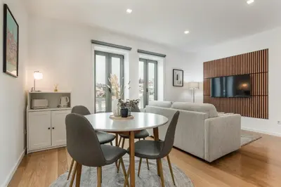 a living room with a table and chairs and a couch at Douro's Bridge View - Swimming pool in Vila Nova de Gaia