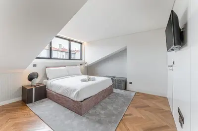 a bedroom with a bed and a tv on a wall at Sao Lazaro Premium Apartments in Porto