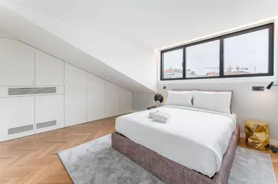a white bedroom with a large bed and a window at Sao Lazaro Premium Apartments in Porto