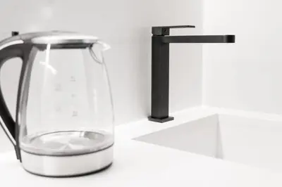 a glass pitcher of water next to a faucet at Sao Lazaro Premium Apartments in Porto