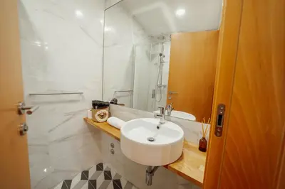 a white bathroom with a sink and a shower at Chillout Trindade Home by Vacationy in Porto