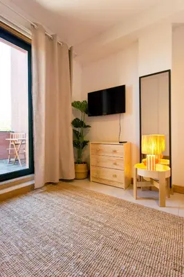 a living room with a tv and a large window at Aposentus - Contemporary Comfort in Porto