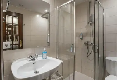 a bathroom with a sink and a shower at Office Suits in Flores by D&S in Porto