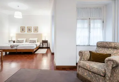 a living room with a couch and a bed at Office Suits in Flores by D&S in Porto