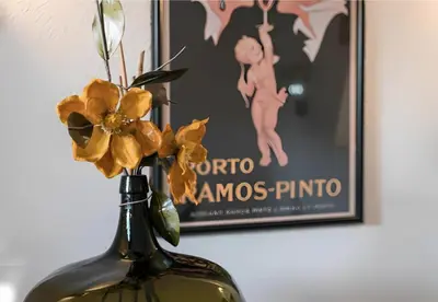 a vase with yellow flowers in front of a movie at Office Suits in Flores by D&S in Porto