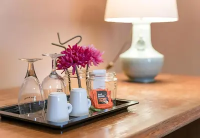 a tray with bottles and vases on a table with a lamp at Office Suits in Flores by D&S in Porto