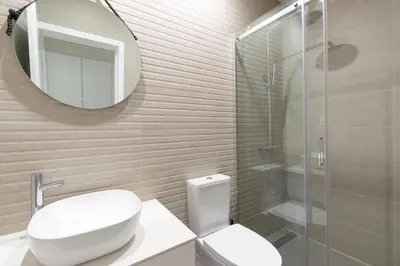 a bathroom with a toilet and a glass shower at Bolhão Market Apartment in Porto