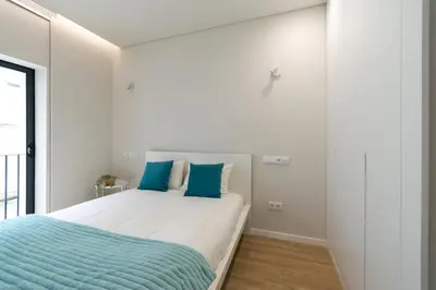 a bedroom with a white bed with orange pillows at Bolhão Market Apartment in Porto