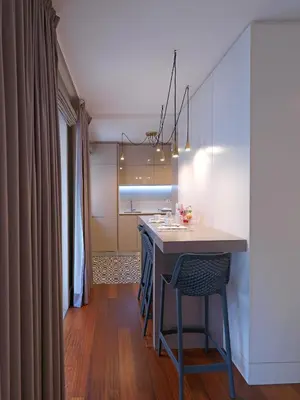 a kitchen with a table and a chair in a room at New Oporto Apartments - Cardosas in Porto