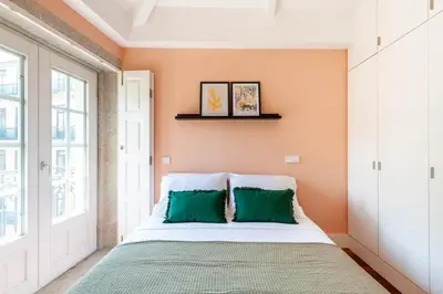 a bedroom with a bed with green pillows at Superb Apartment in the HEART of Historical Center in Porto