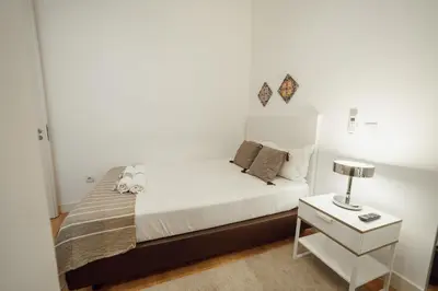 a small bedroom with a white bed and a nightstand at Downtown Elegant by Hosty in Porto