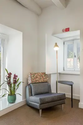 a living room with a chair and a table at By the River 1 by Porto Dream Stays in Porto