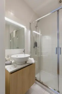 a white bathroom with a sink and a shower at By the River 2 by Porto Dream Stays in Porto