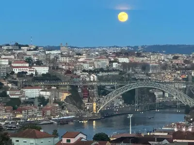 a view of a city with a bridge and the moon at New Douro 403 with parking in Vila Nova de Gaia