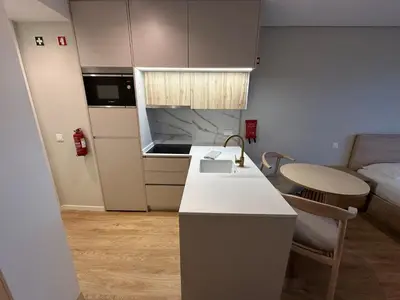a small kitchen with a sink and a table at New Douro 403 with parking in Vila Nova de Gaia
