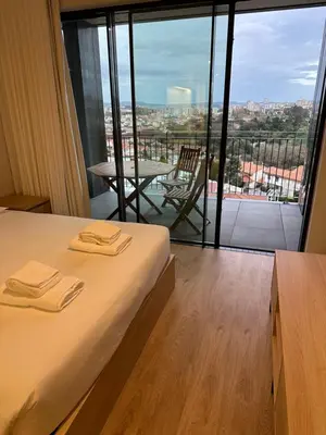 a hotel room with a bed and a balcony with a view at New Douro 403 with parking in Vila Nova de Gaia