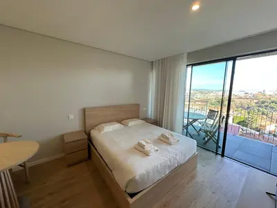 a bedroom with a bed and a large window at New Douro 403 with parking in Vila Nova de Gaia