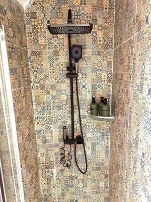a shower with a shower head on a tiled wall at Casa Moara - Downtown Duplex House in Porto
