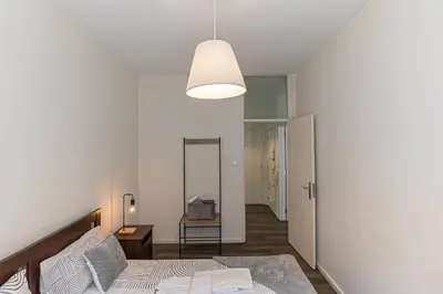 a white bedroom with a bed and a lamp at Now Trindade in Porto