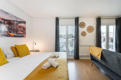 a bedroom with a large white bed and a couch at GuestReady - Homey experience in Porto in Porto
