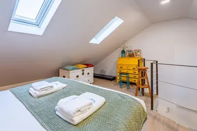 a attic bedroom with a bed with towels on it at Essence Oporto Apartment Downtown in Porto