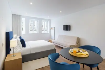 a hotel room with a bed and a table and chairs at Feel Porto Lapa Collection Flats in Porto