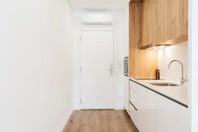a kitchen with white cabinets and a sink at Feel Porto Lapa Collection Flats in Porto