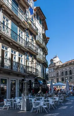a group of tables and chairs in front of a building at Cardosas Charming Apartment with Balconies in Porto