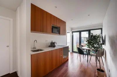 a kitchen with wooden cabinets and a table with a plant at GuestReady - Silk Factory Studios and Apartments in Porto