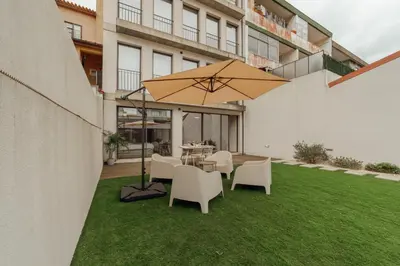 a patio with a table and chairs and an umbrella at Gaia Premium Apartments by Vacationy in Porto