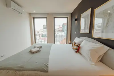 a large white bed in a room with a window at Gaia Premium Apartments by Vacationy in Porto
